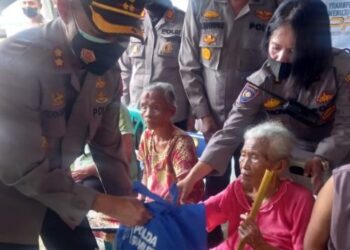 Kapolresta Siantar saat menyerahkan Bansos kepada salah seorang warga lanjut usia (lansia). (Foto: LimaSisiNews.com/MN).