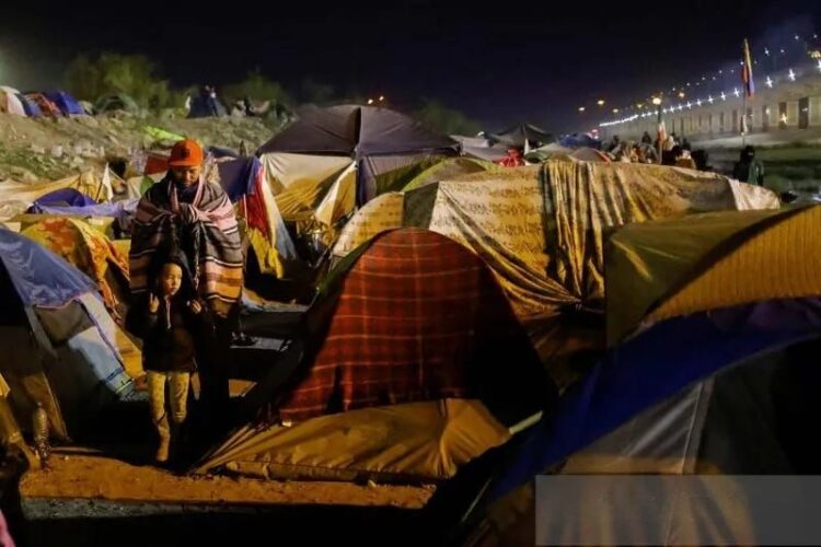 Beberapa Migran Venezuela, diusir dari AS ke Meksiko dan yang lainnya belum menyeberang setelah kebijakan imigrasi yang baru, berdiri di sebuah kamp di tepi sungai Rio Bravo di Ciudad Juarez, Meksiko (14/11/2022). (Foto: Ant./Reuters/José Luis Gonzales/aww).
