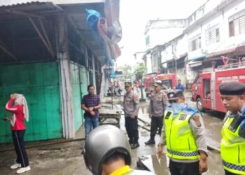 Petugas Pemadam Kebakaran bersama aparat dari Polres Tebing Tinggi dan masyarakat sekitar akhirnya berhasil memadamkan api yang melalap dua uni kios di Pasar Senangin Kota Tebing Tinggi, Minggu (22/01/2023).(Foto: Antara).