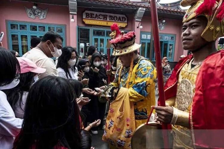 Petugas membagikan kue keberuntungan kepada pengunjung di kawasan Pantjoran Pantai Indah Kapuk (PIK), Jakarta, Minggu (22/01/2023). (Foto: Ant./Aprillio Akbar/rwa.).