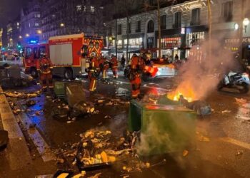 Petugas pemadam kebakaran (damkar) memadamkan tempat sampah yang terbakar pasca demonstrasi menentang reformasi pensiun di Paris, Prancis, (20/03/2023). (Foto: Ant. dari Reuters/Bart Biesemans/as).