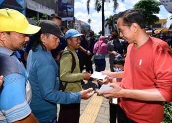 Presiden Joko Widodo membagikan bantuan kepada para pedagang di Pasar Legi, Kota Surakarta, Kamis (20/04/2023). (Foto: BPMI Setpres/Lukas).