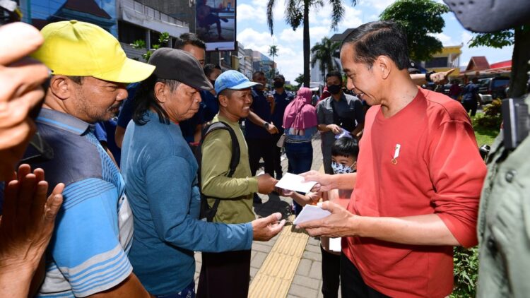 Presiden Joko Widodo membagikan bantuan kepada para pedagang di Pasar Legi, Kota Surakarta, Kamis (20/04/2023). (Foto: BPMI Setpres/Lukas).