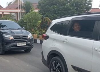 Tampak Bupati Labuhanbatu Erik sempat membuka kaca mobil dan melambaikan tangan kanannya ke sejumlah warga.